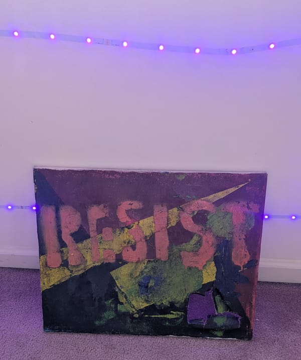 Purple LED lights outline a green, yellow and red painting with the word RESIST stenciled on, the canvas has a tear on the bottom right